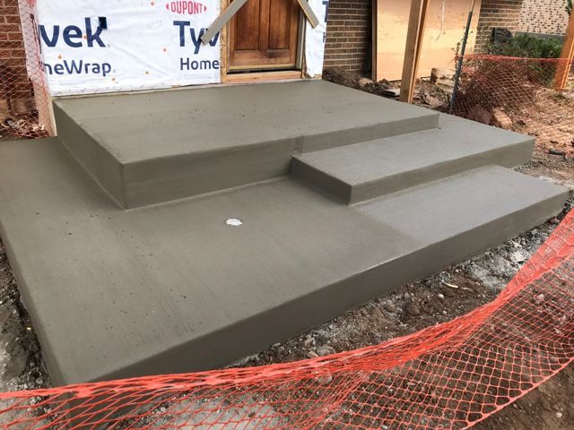 A concrete staircase is being built in front of a house.