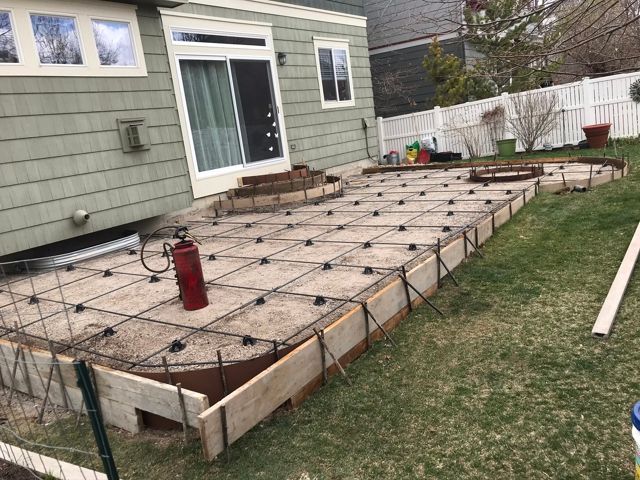 A patio is being built in the backyard of a house.