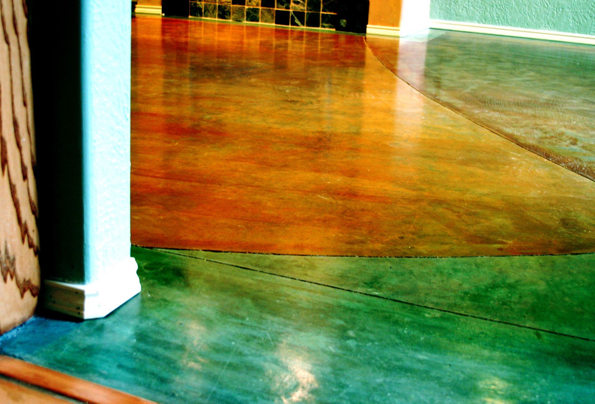 A colorful concrete floor in a room with a corner.
