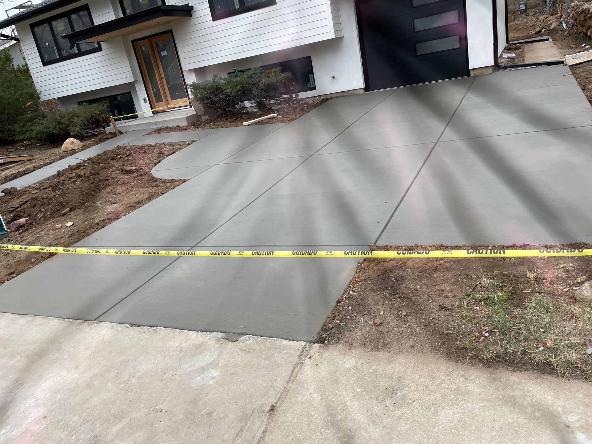 A concrete driveway is being built in front of a house.