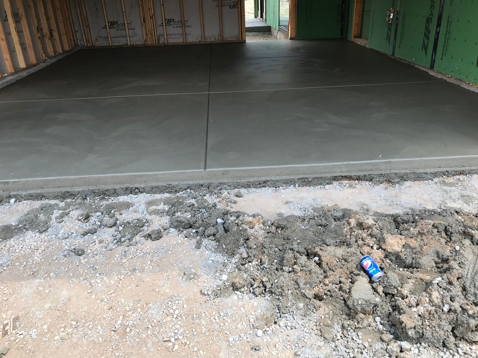 A garage with the door open and a ladder in it.