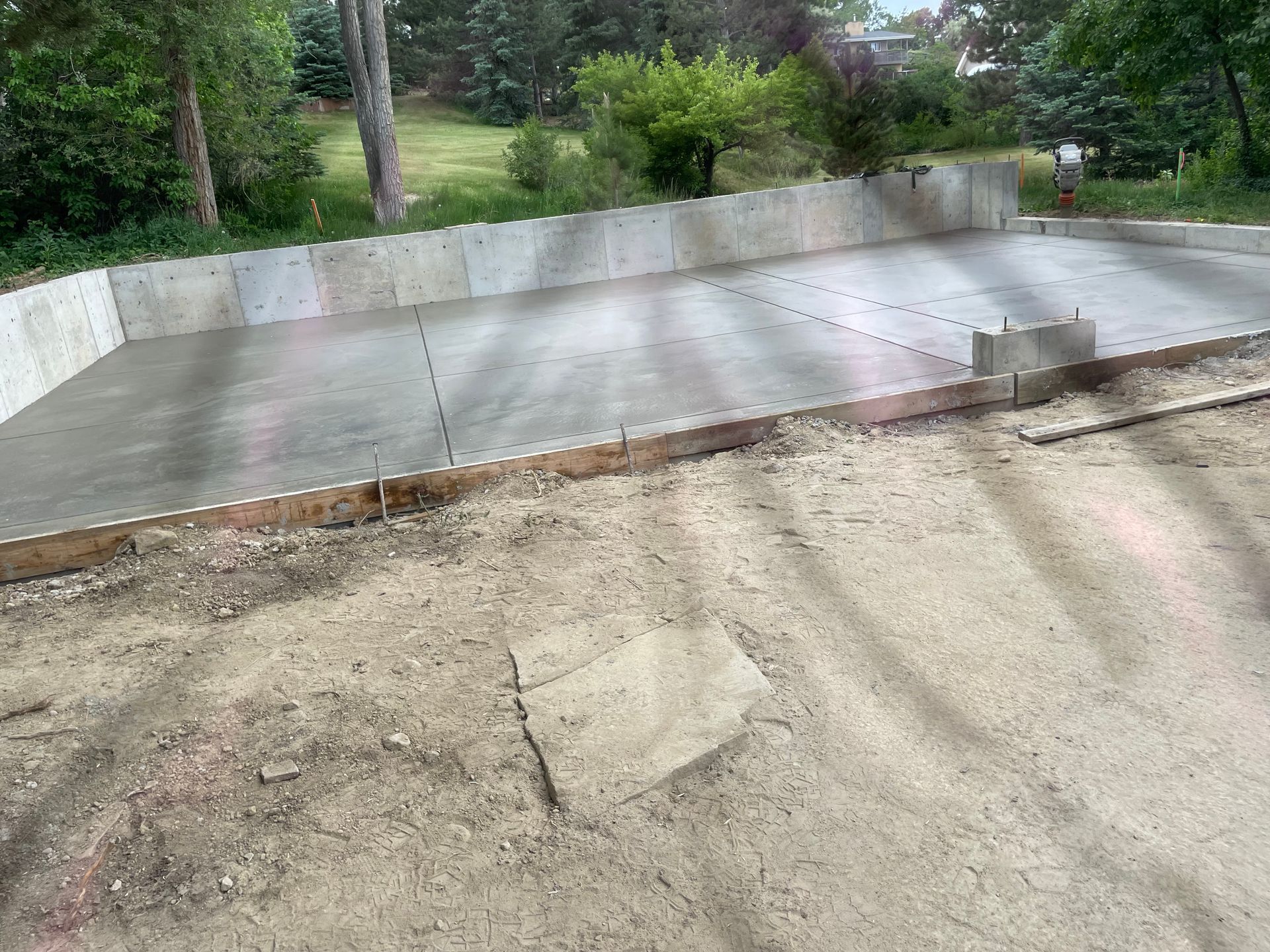 A concrete driveway is being built in a backyard.