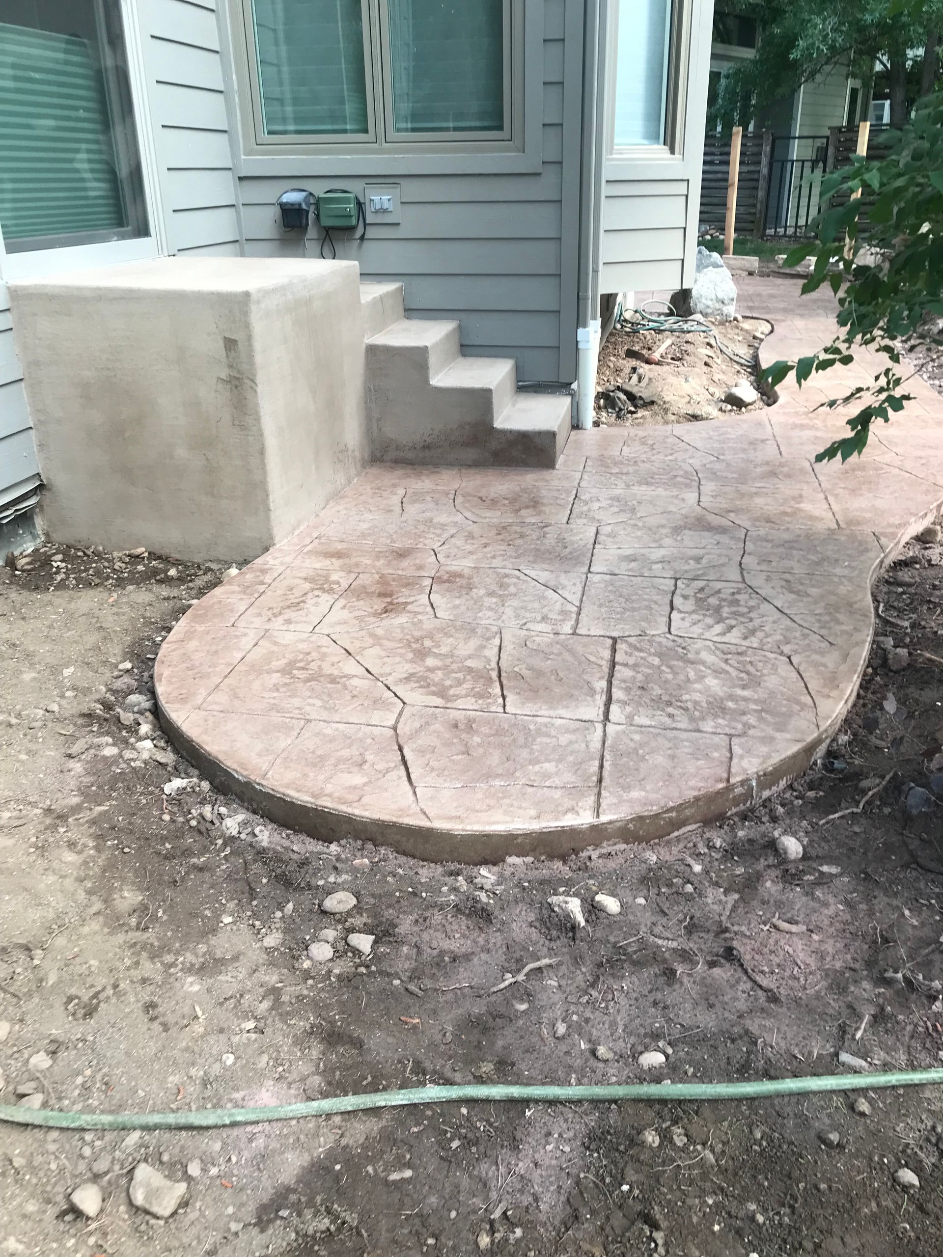 A set of concrete stairs with a diagonal pattern A concrete walkway is being built in front of a house.
