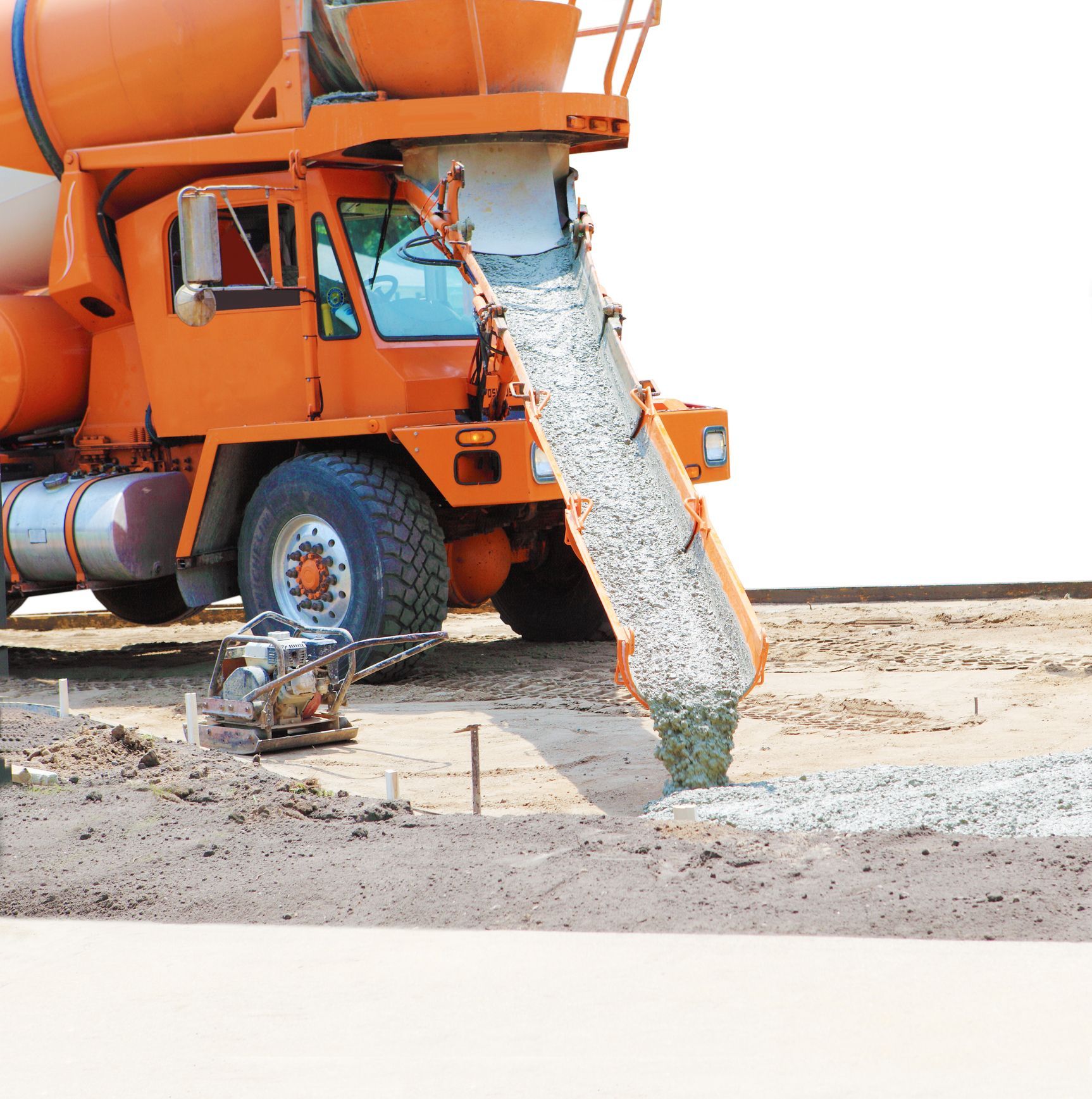 A concrete mixer truck is pouring concrete into the ground