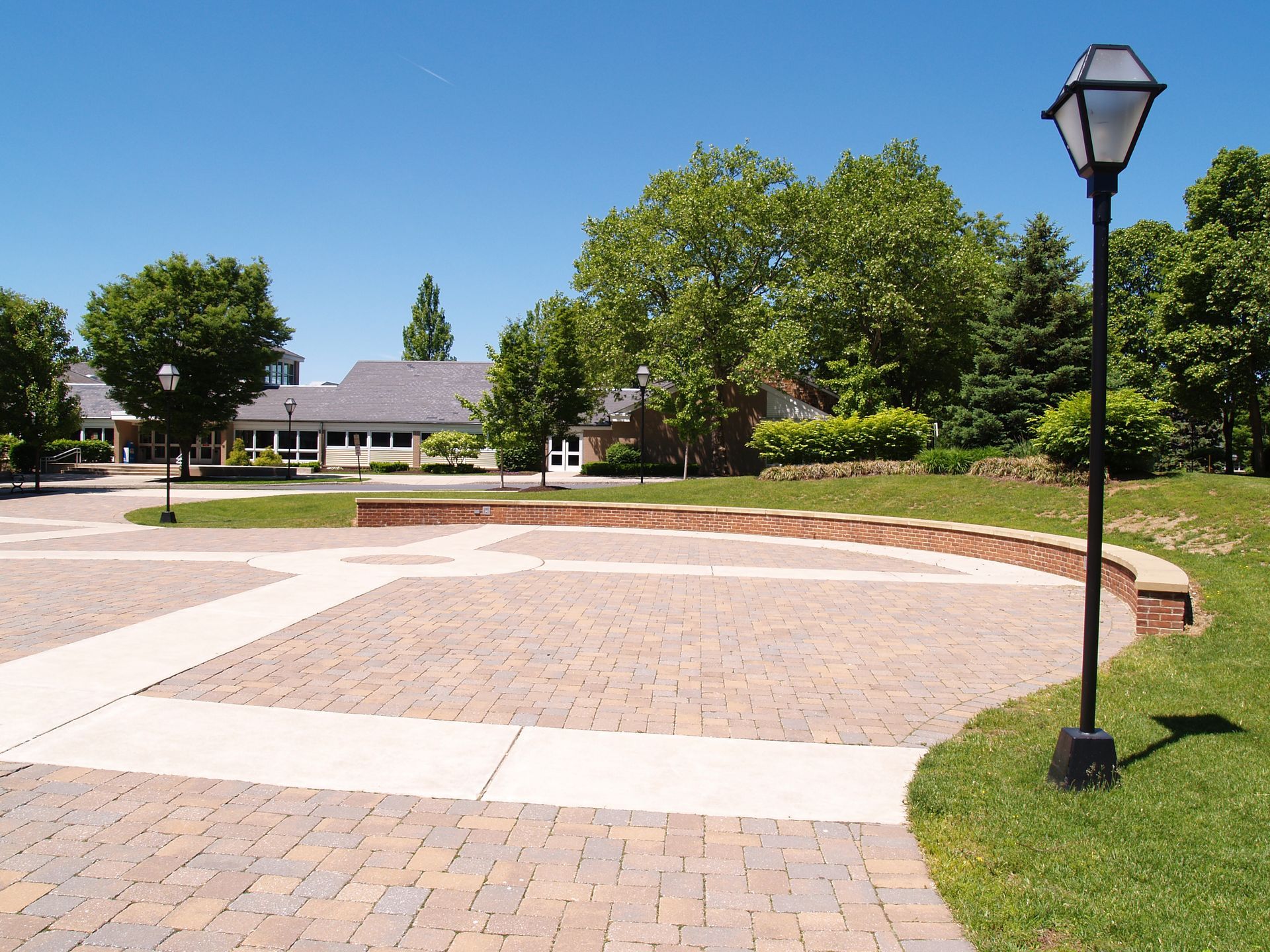 A brick walkway with a lamp post in the foreground