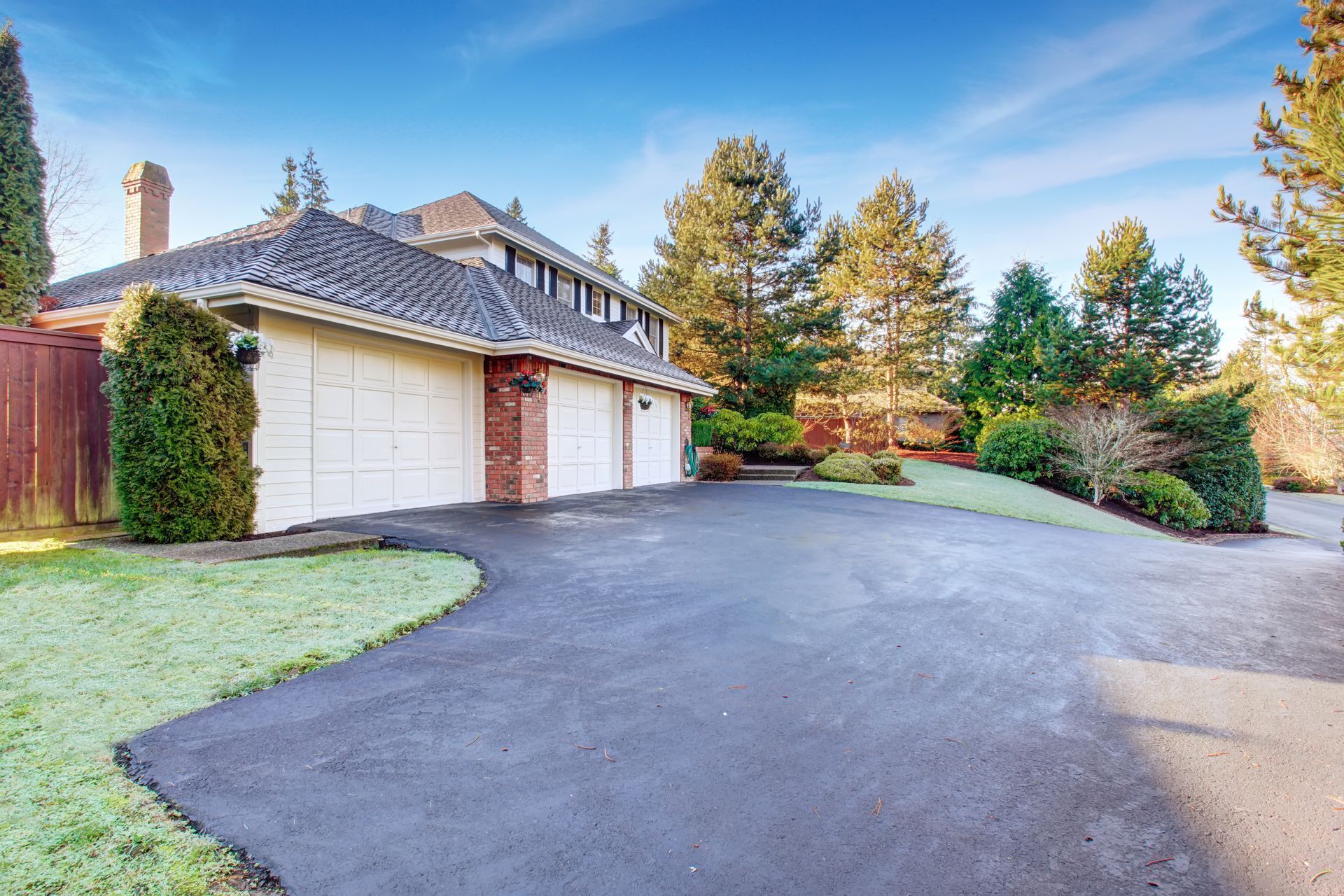 A large white house with a large driveway leading to it.
