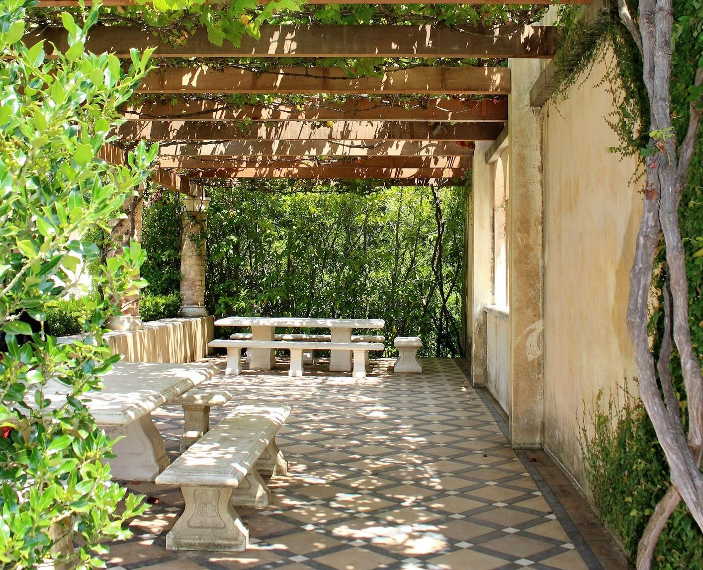 There is a pergola with a picnic table underneath it.