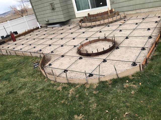 A patio is being built in the backyard of a house.