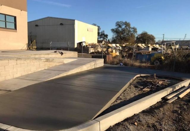 A concrete ramp is being built in front of a building.