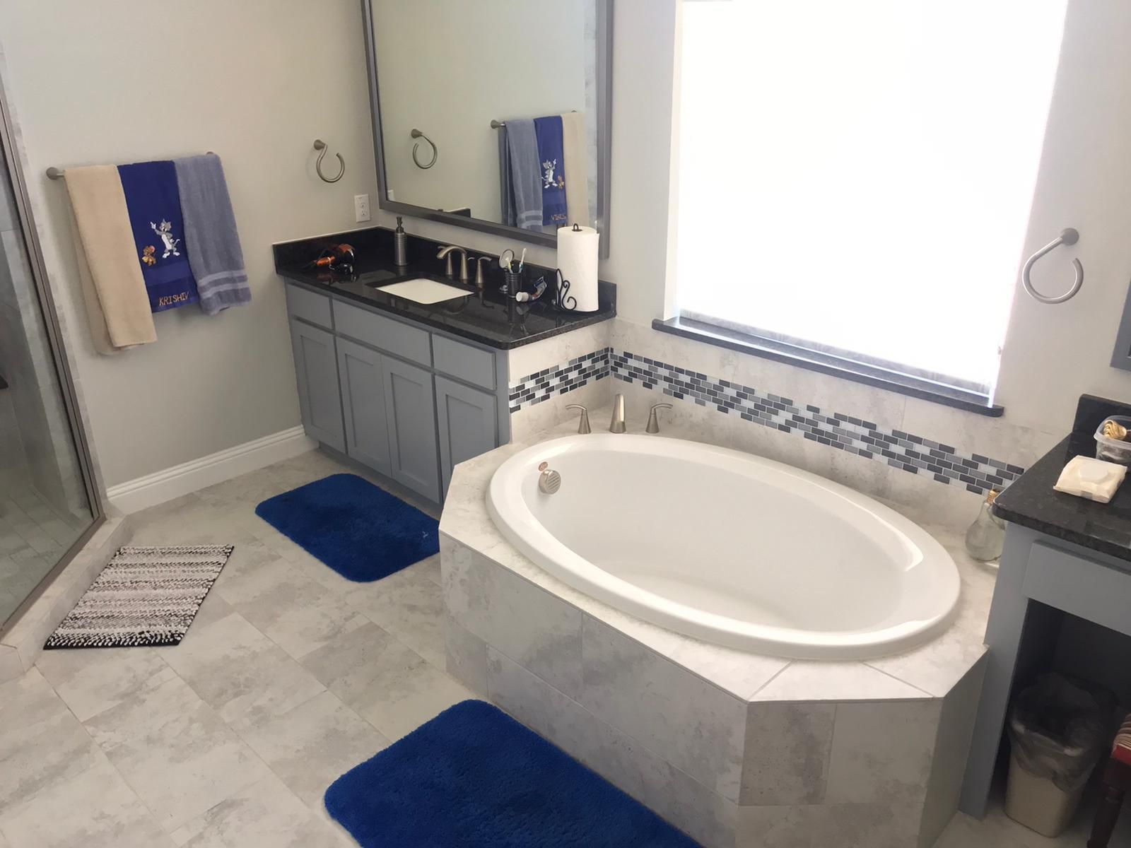 A bathroom with a tub , sink and mirror