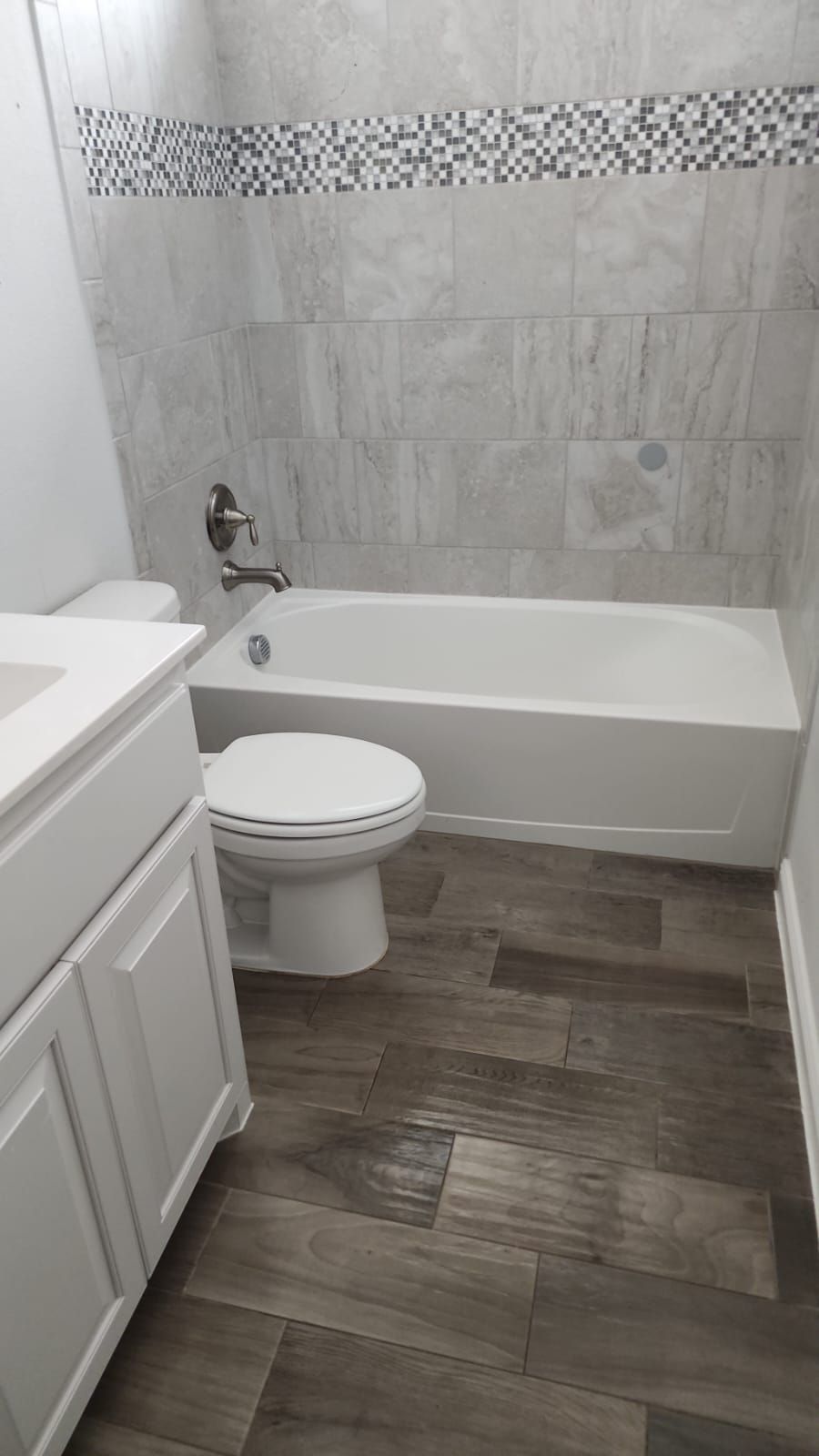 A bathroom with a toilet , sink and bathtub.