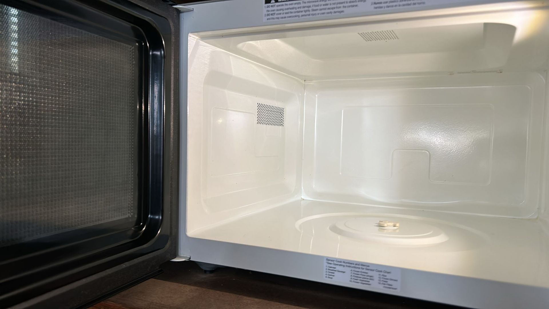 The inside of an empty microwave oven with the door open.