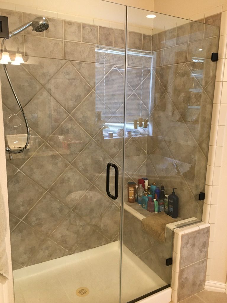 A bathroom with a walk in shower with a glass door.