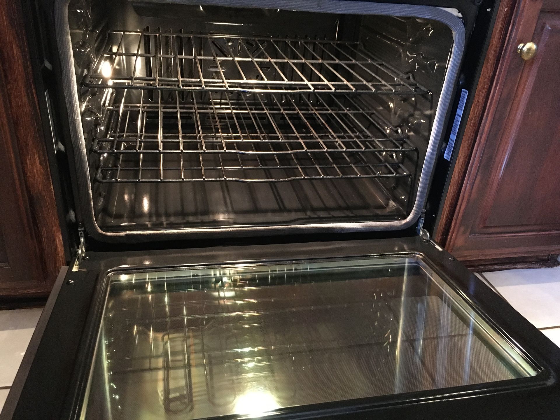 A stainless steel oven with the door open in a kitchen.