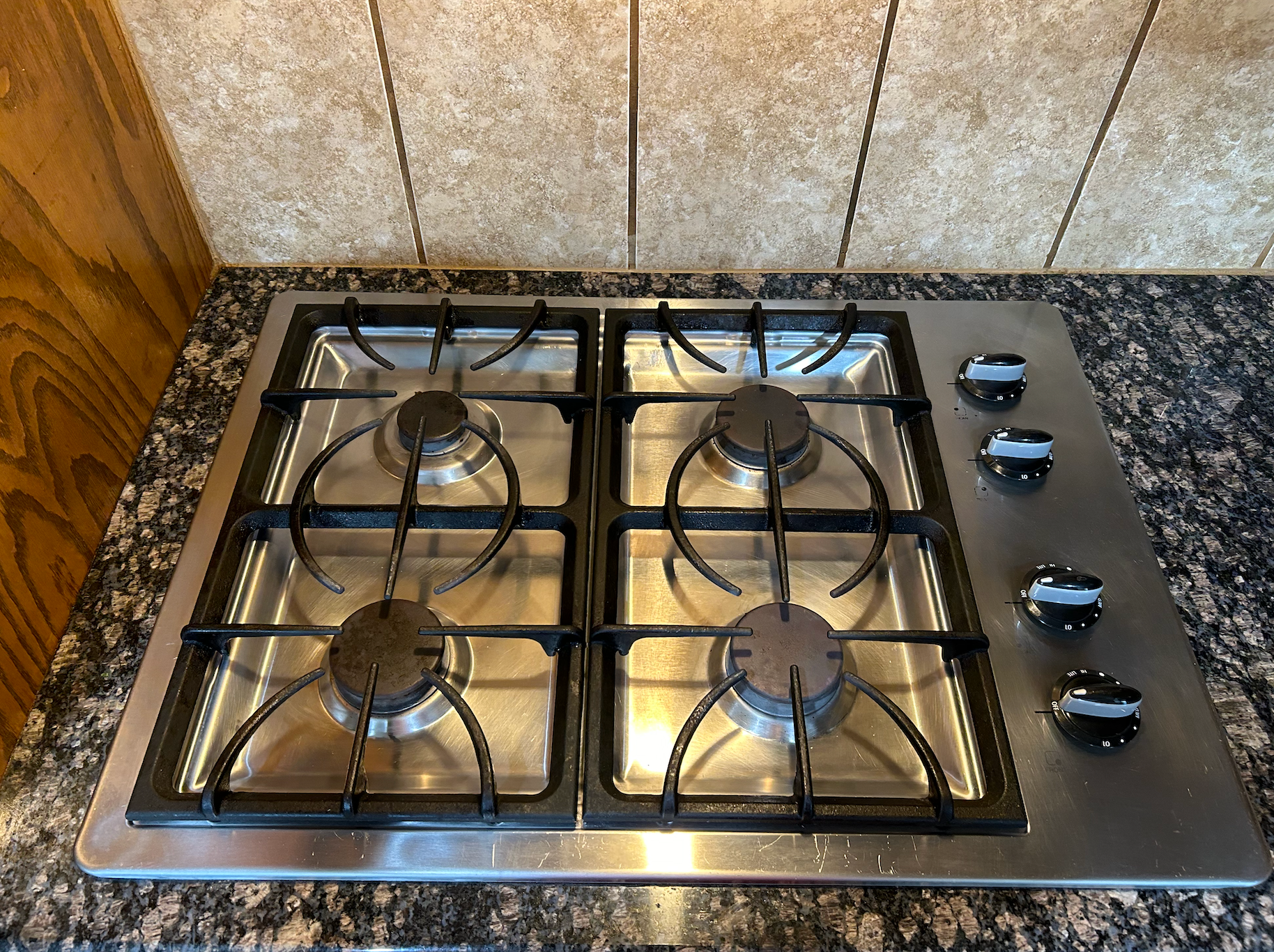 A stainless steel stove top oven is sitting on top of a granite counter.