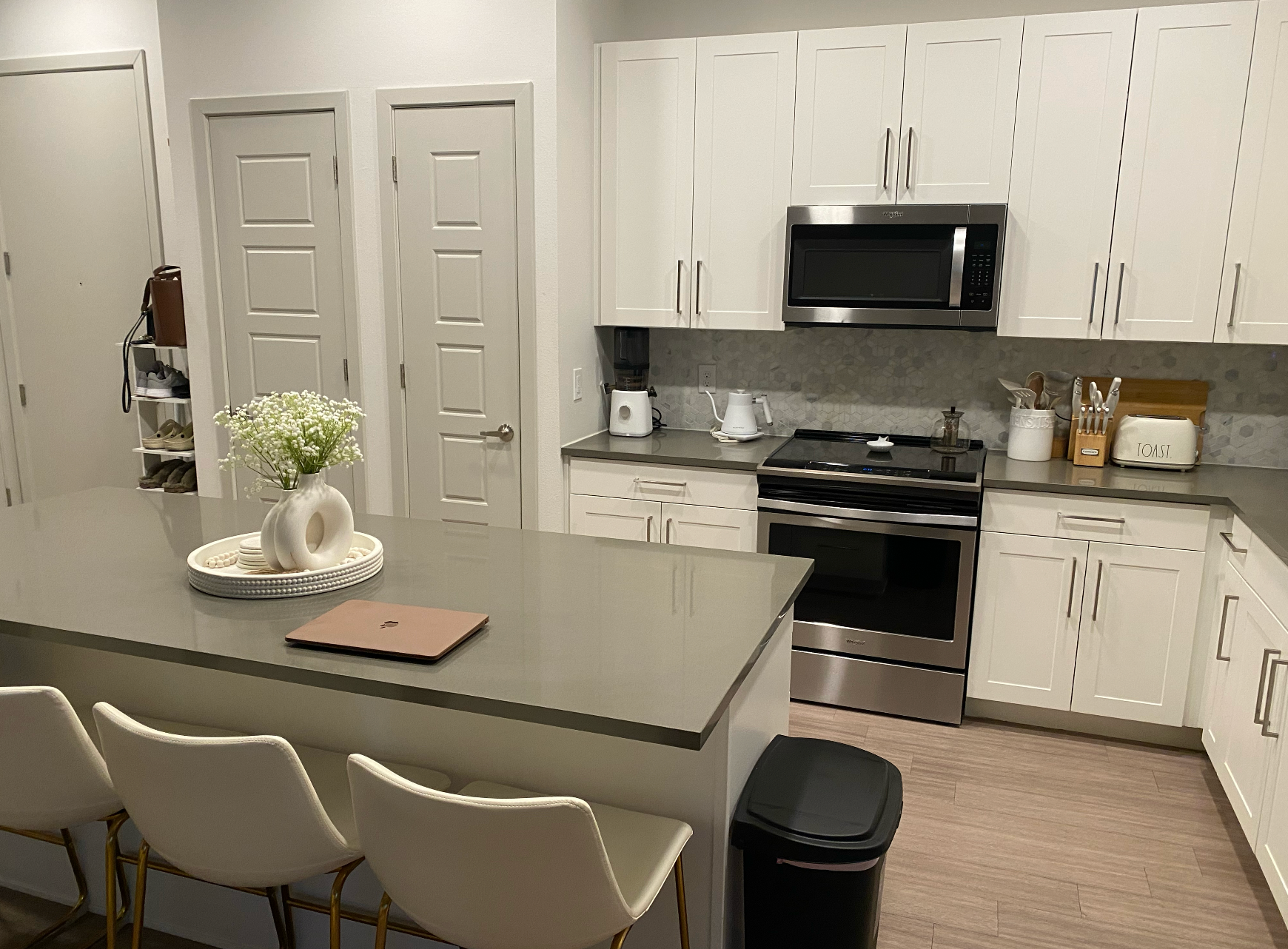 A kitchen with white cabinets and stainless steel appliances.