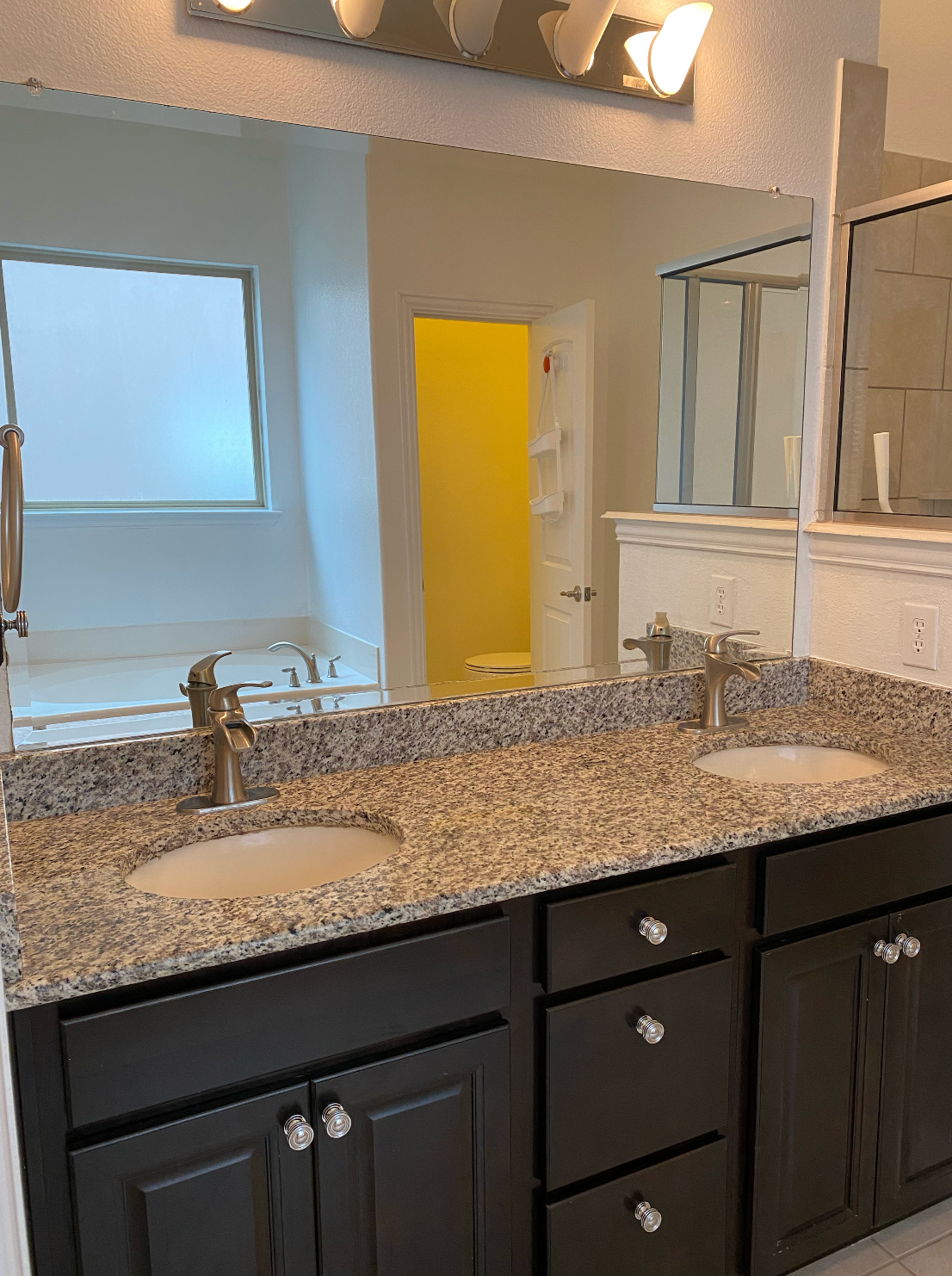 A bathroom with two sinks and a large mirror