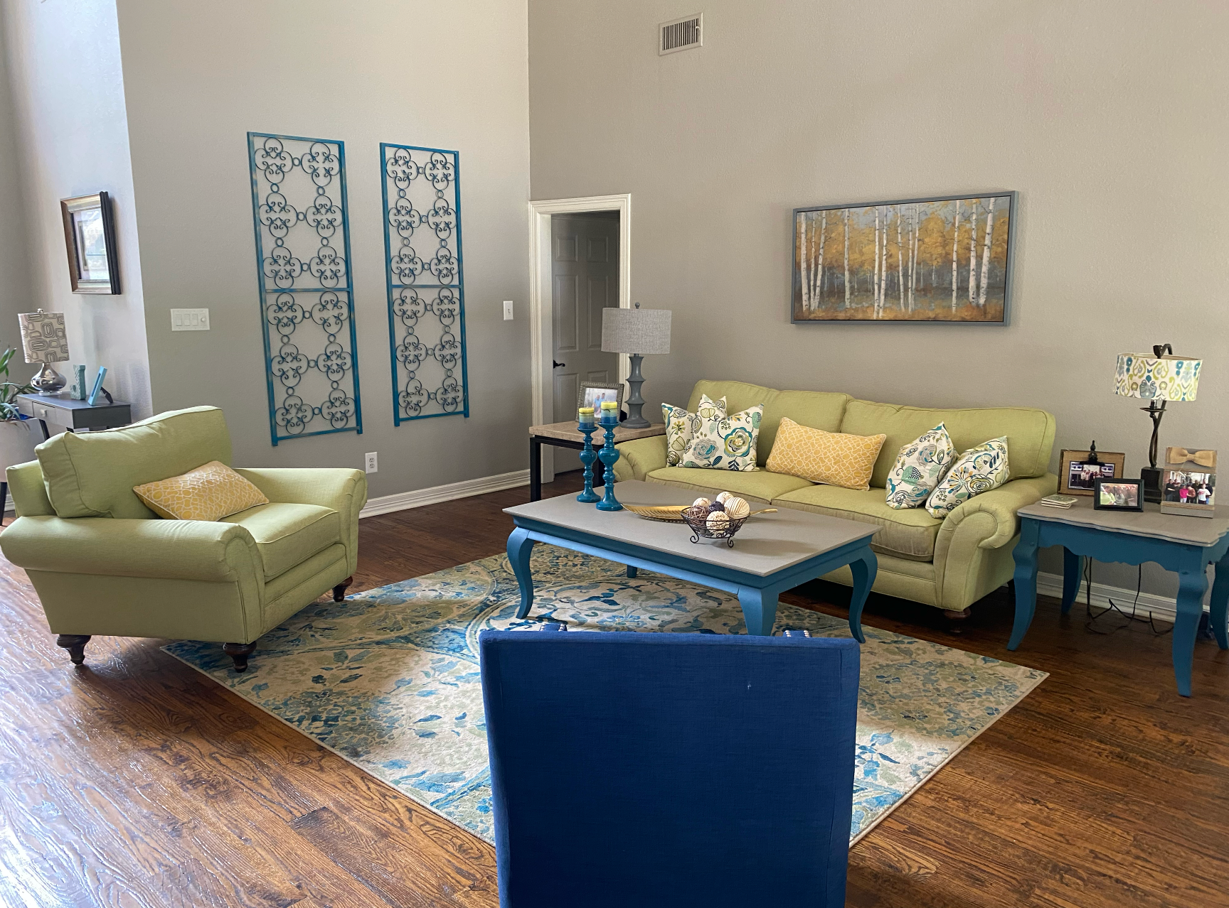 A living room with a couch , chair , coffee table and rug.