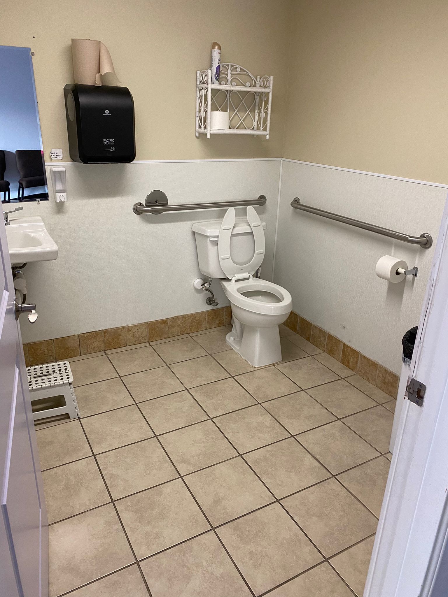 A bathroom with a toilet , sink and mirror.