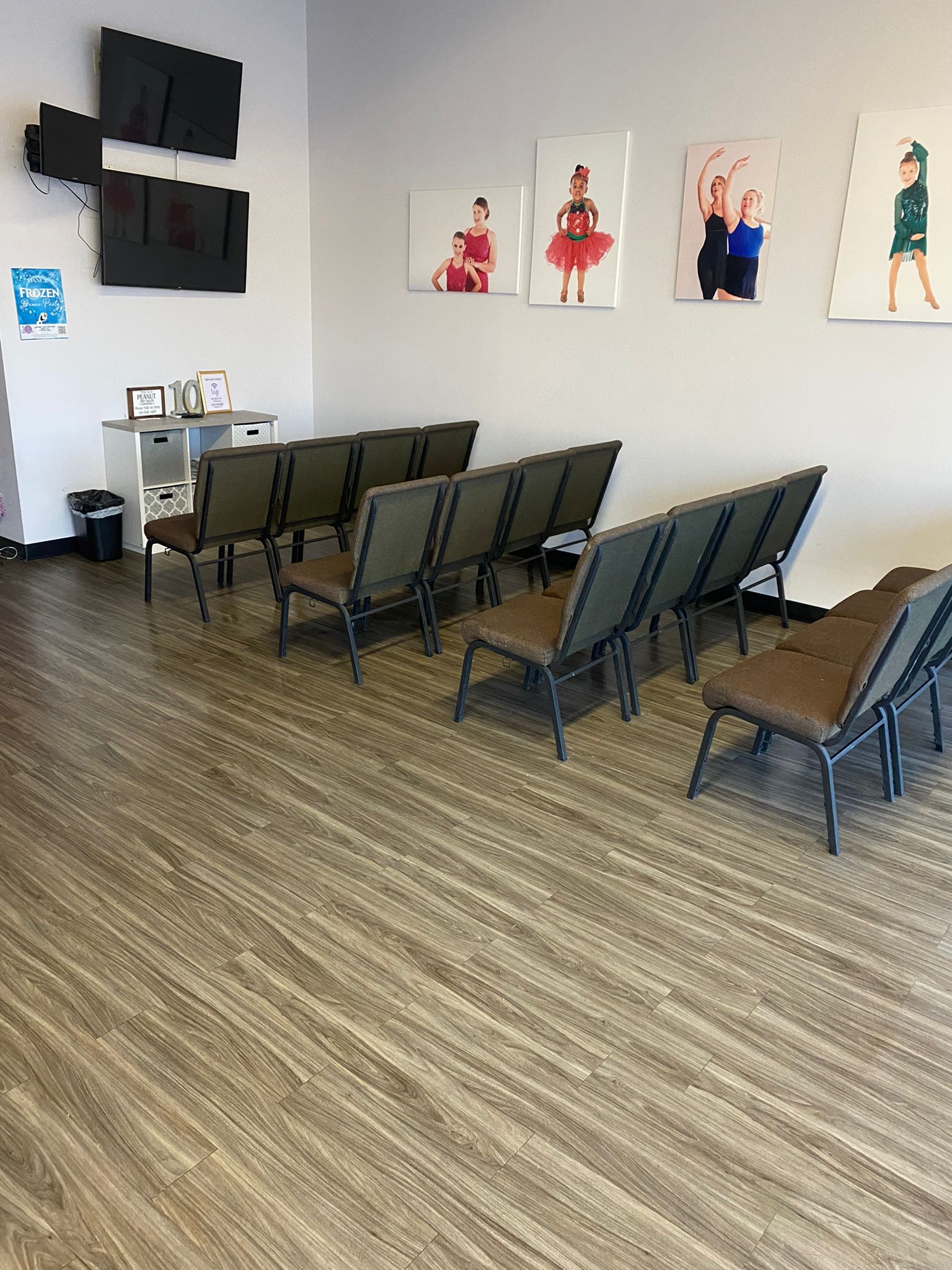 A waiting room with a lot of chairs and pictures on the wall.
