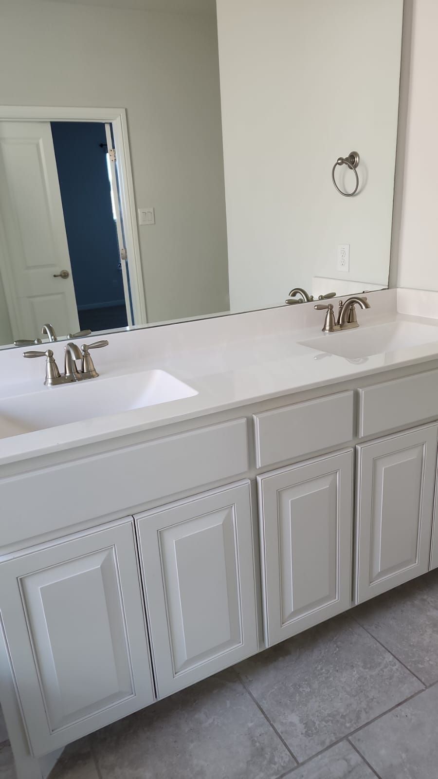 A bathroom with two sinks and a large mirror.
