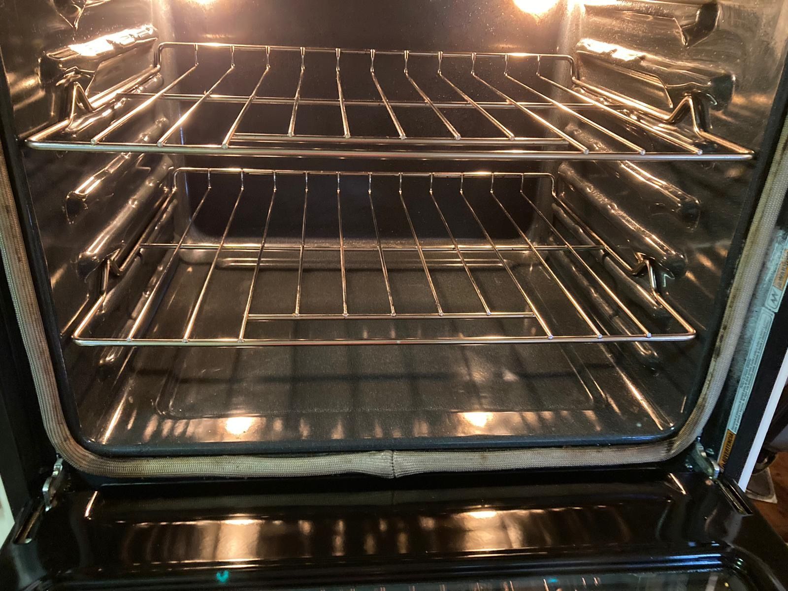 The inside of an oven with the door open and the lights on.