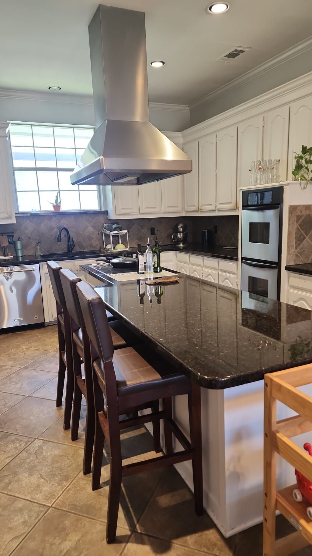 A kitchen with a large island and stools.