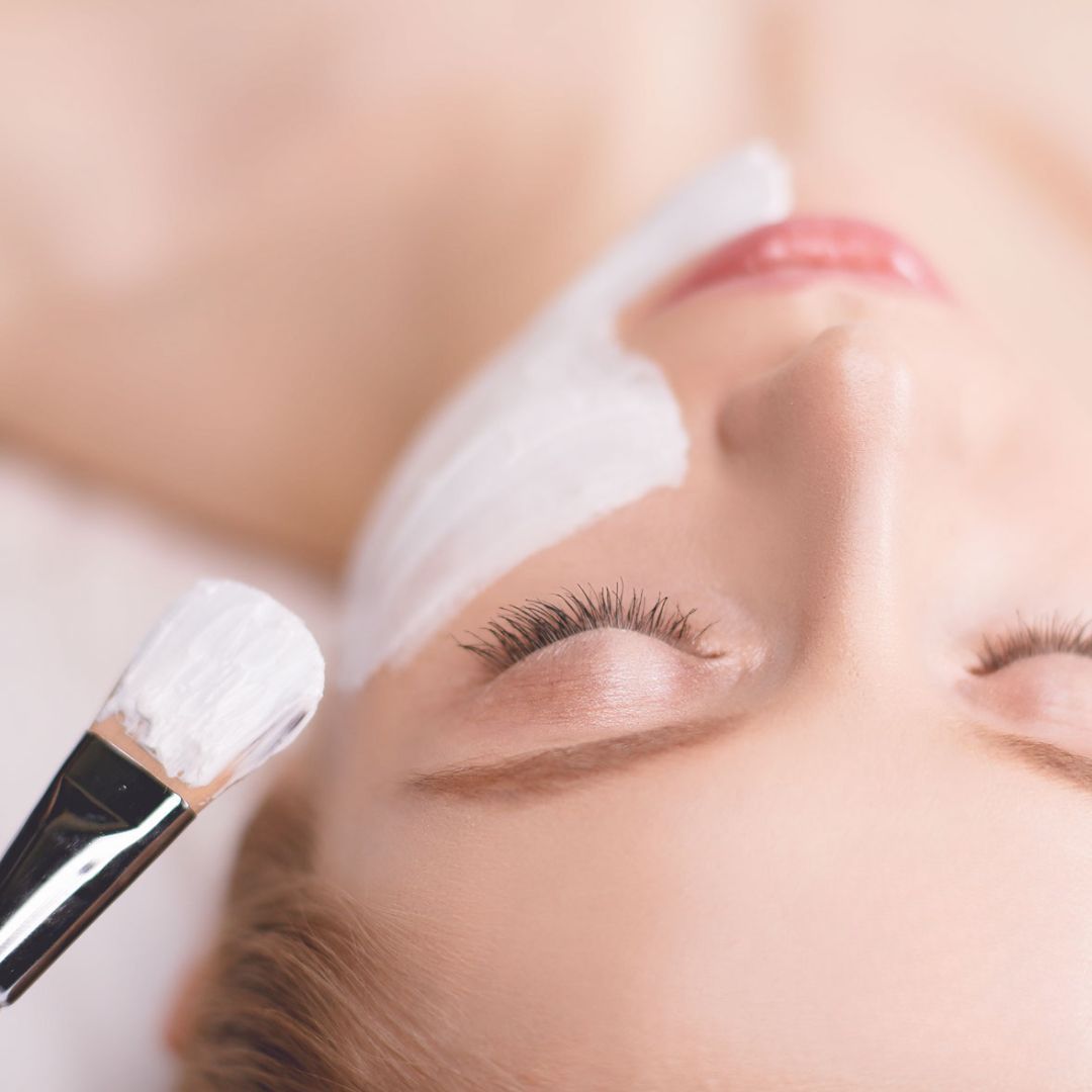 Una donna sta ricevendo un trattamento viso con una spazzola sul viso.