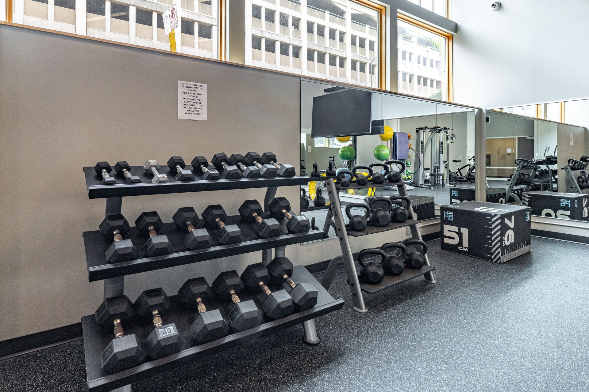 Gym with dumbbell racks, kettlebells, mirrors, and workout equipment at R7 Lofts in St. Paul, MN.
