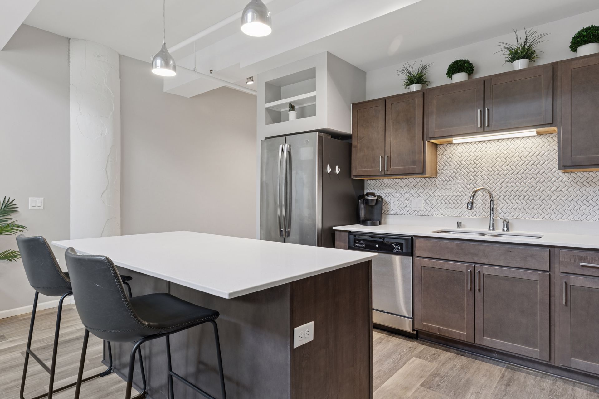 Modern kitchen with island, stainless steel appliances, and dark cabinets at R7 Lofts in St. Paul, MN.