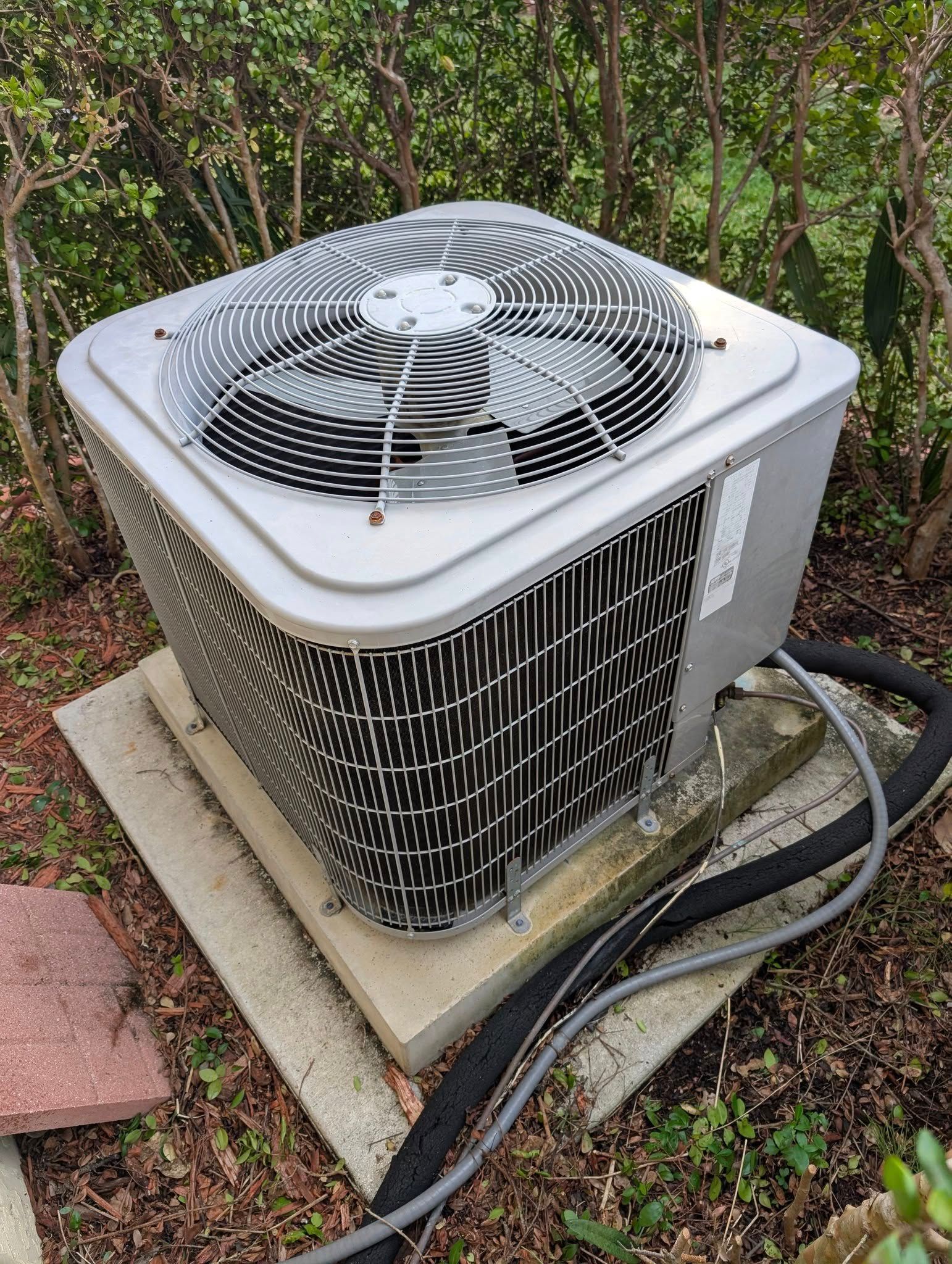 A large air conditioner is sitting on top of a concrete platform.