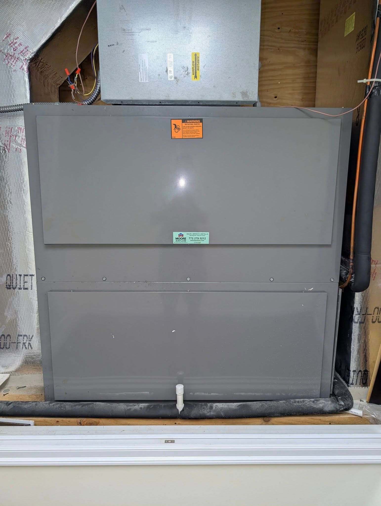 A large gray box is sitting in a room next to a window.