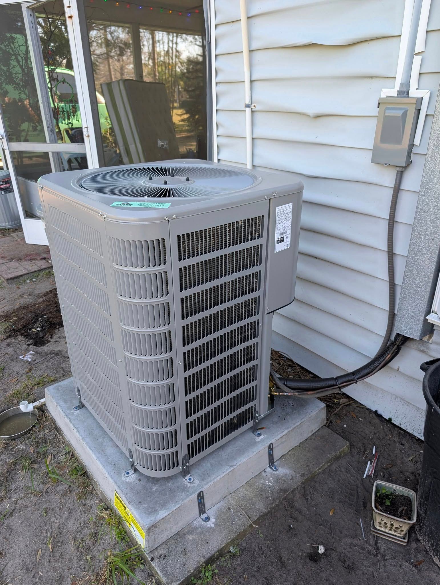 A large air conditioner is sitting on the side of a house.
