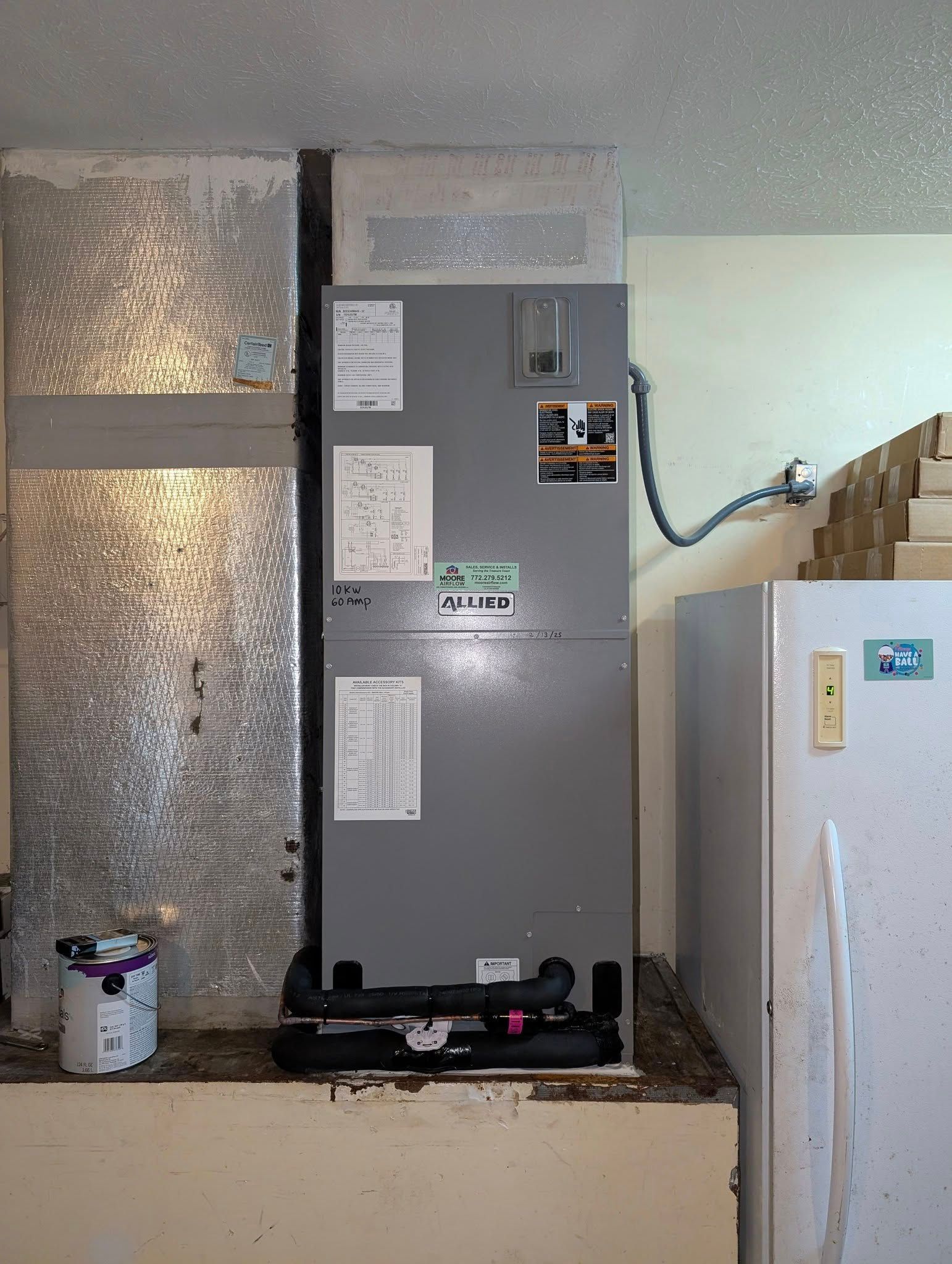 A refrigerator is sitting next to a heater in a room.