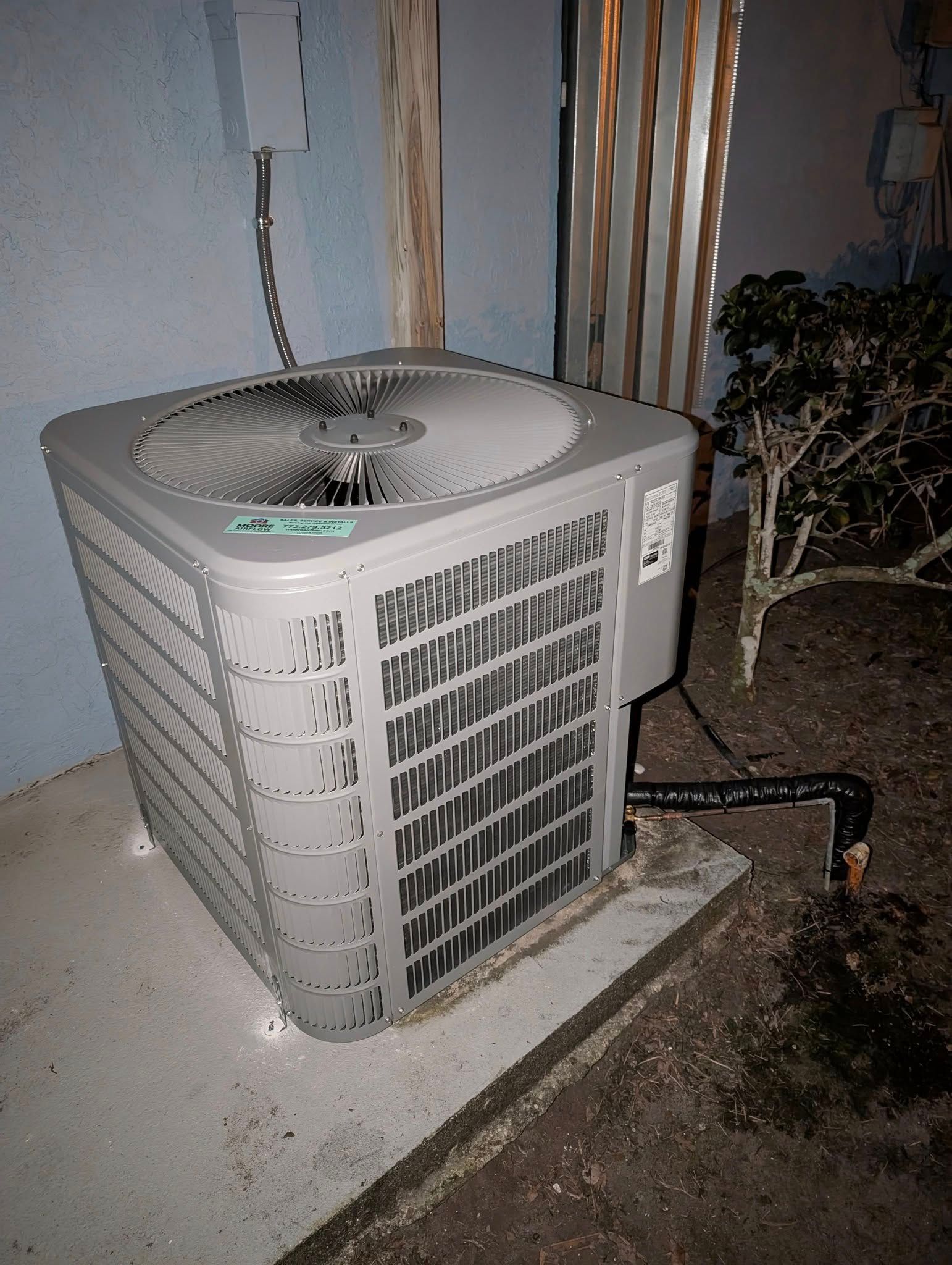 A dirty air conditioner is sitting on the side of a building.