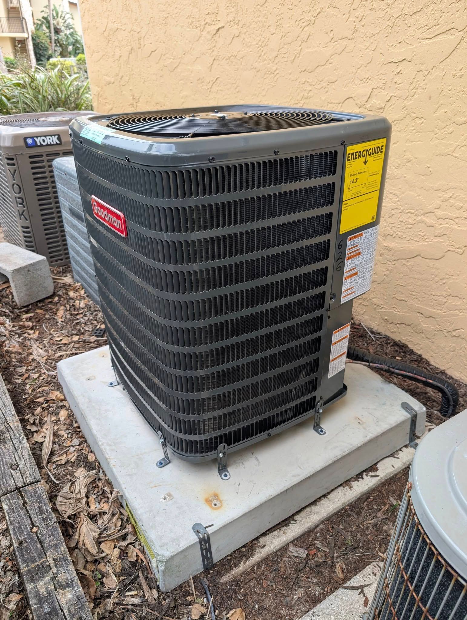 A large air conditioner is sitting on top of a concrete platform.