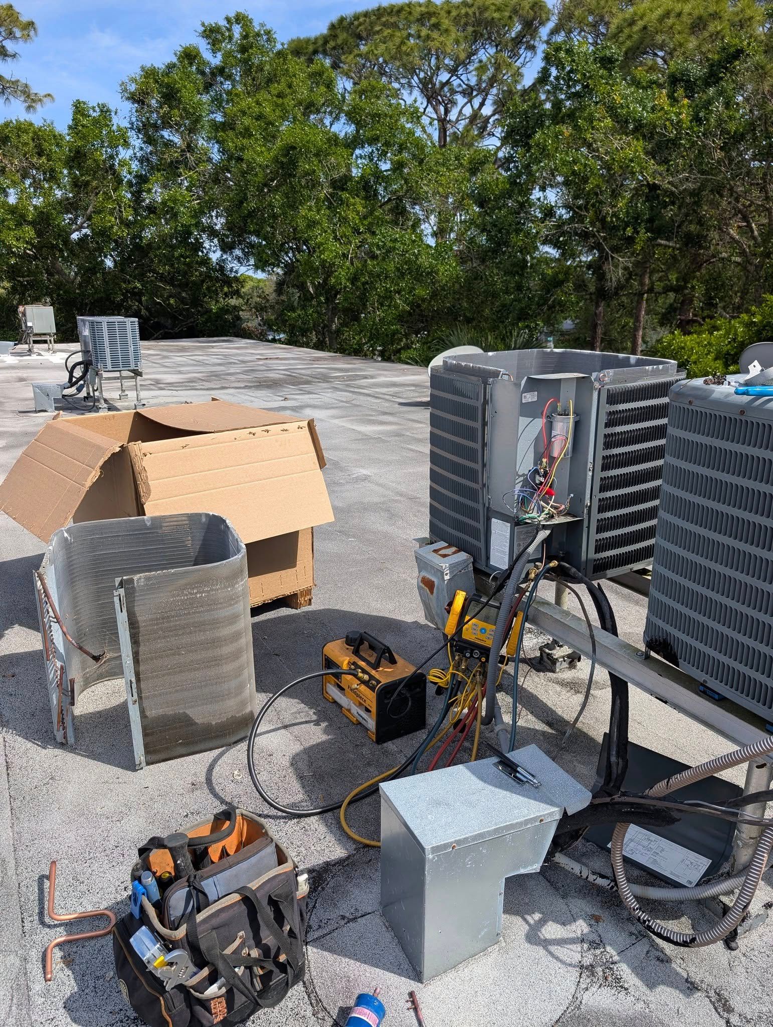 A couple of air conditioners are sitting on top of a roof.