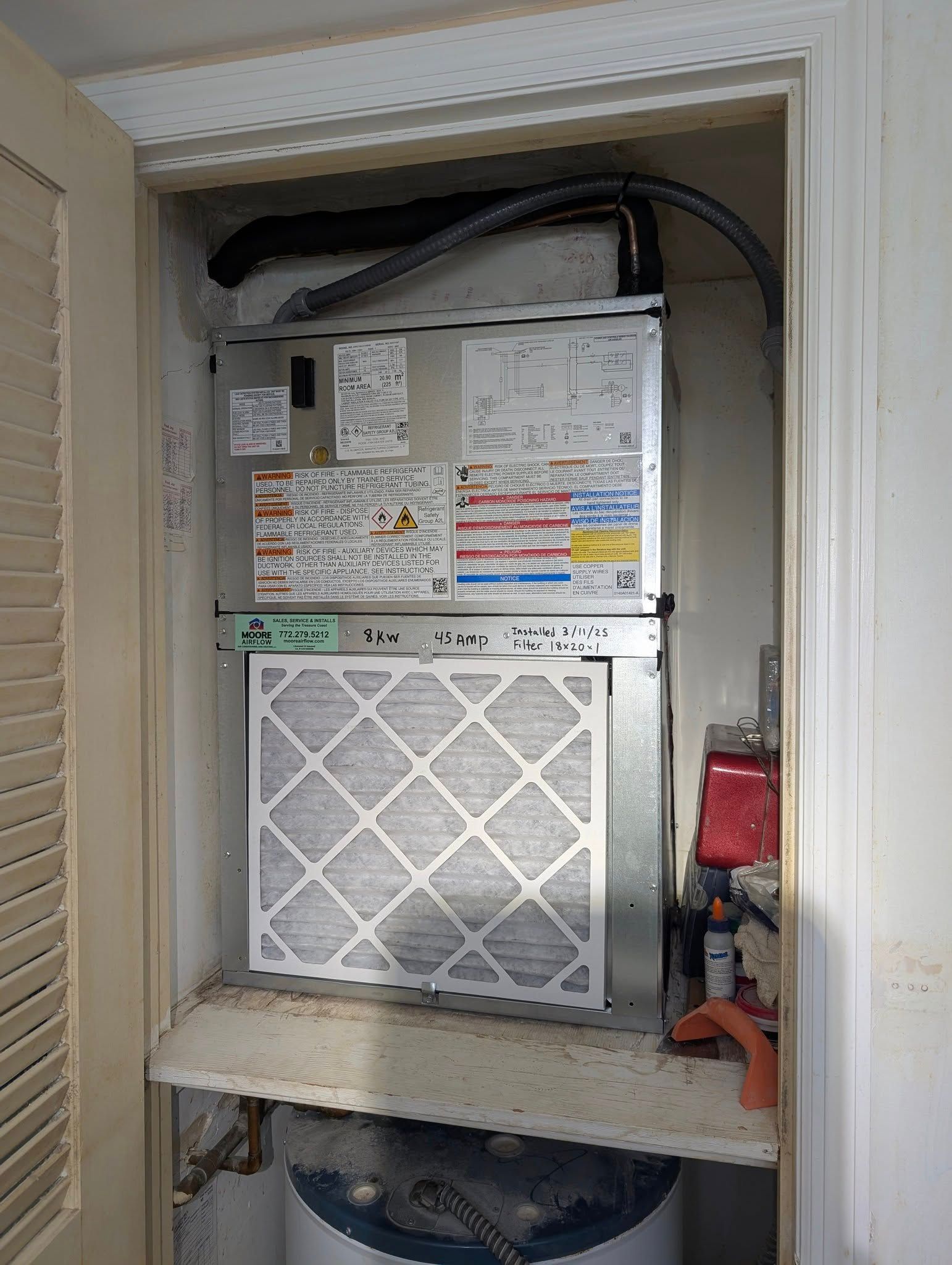 An air conditioner is sitting inside of a closet.