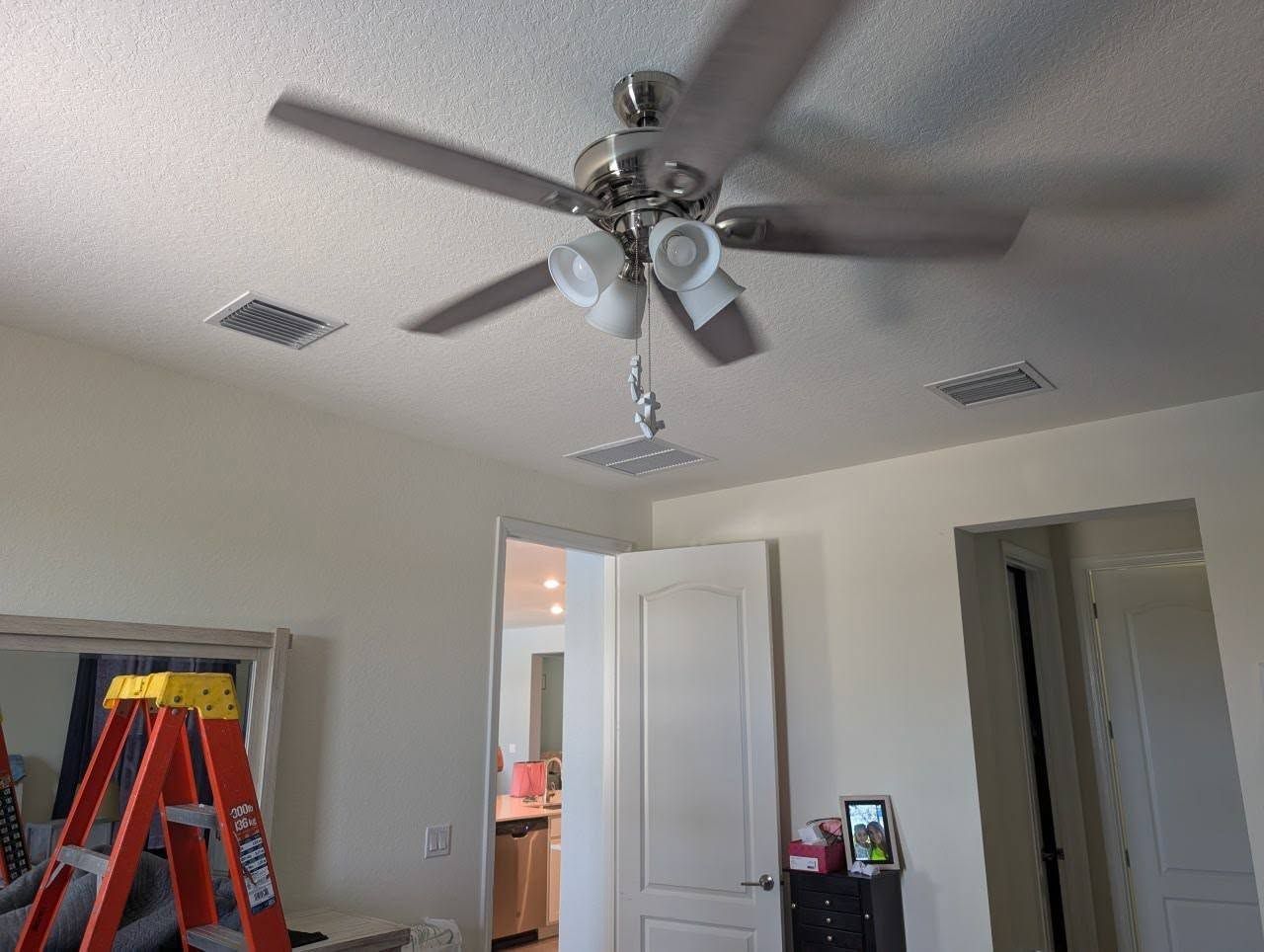 A ceiling fan is hanging from the ceiling of a bedroom.