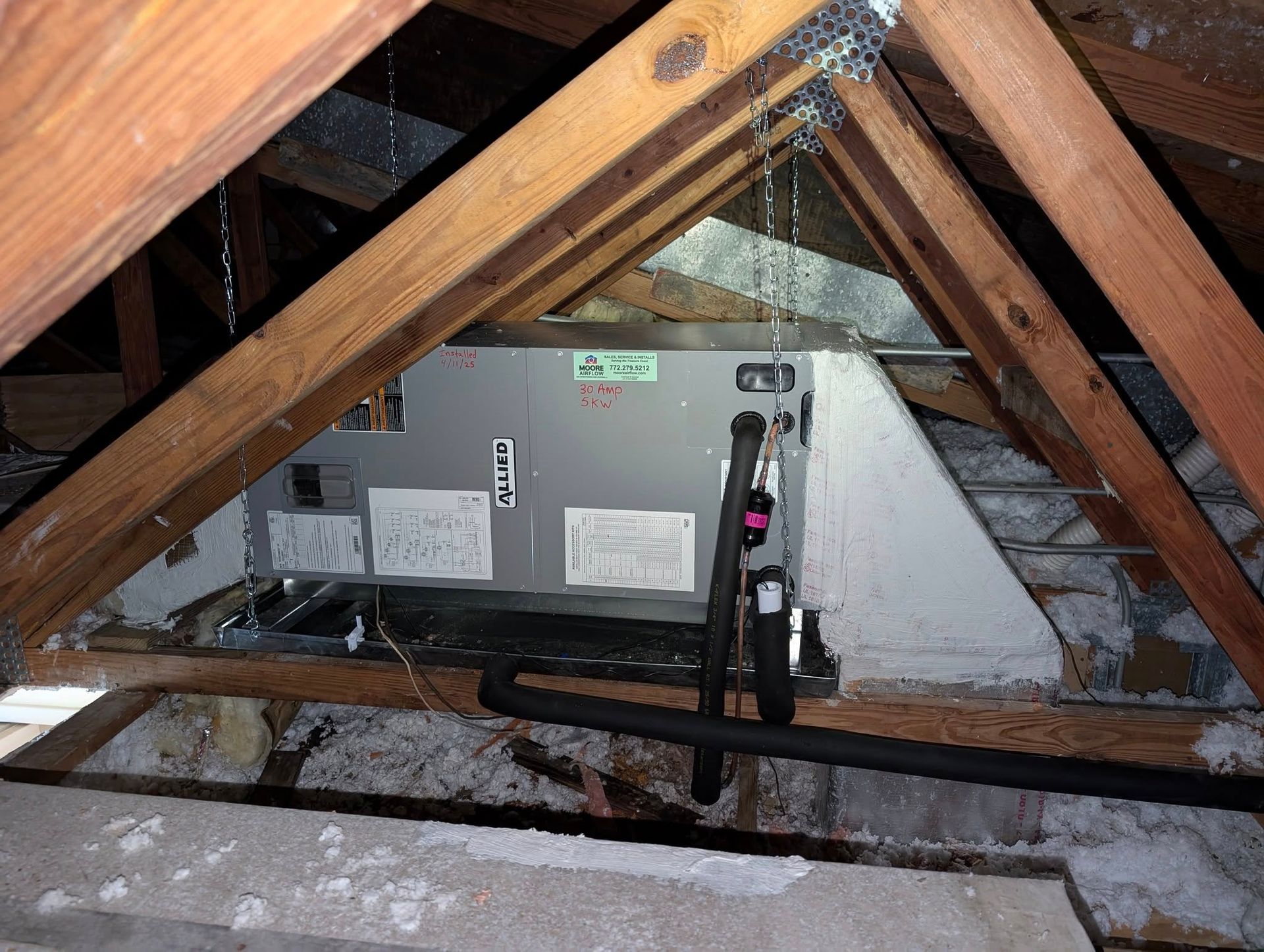 An air conditioner is installed in the attic of a house
