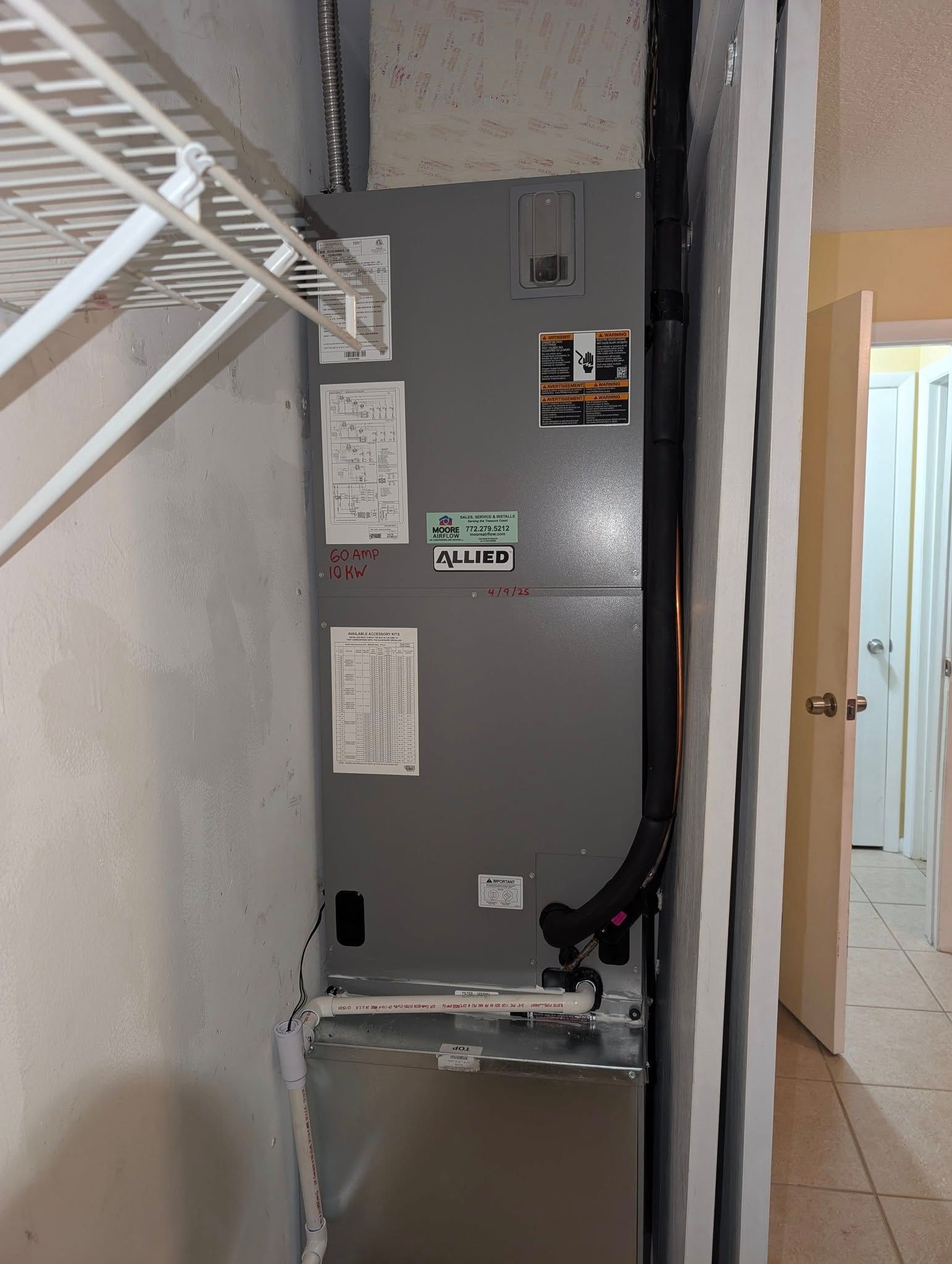 A room with a closet and a refrigerator in it.