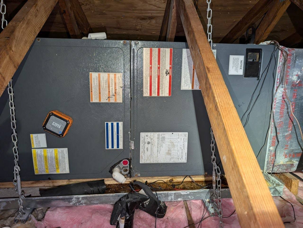 An air conditioner is being installed in the attic of a house.