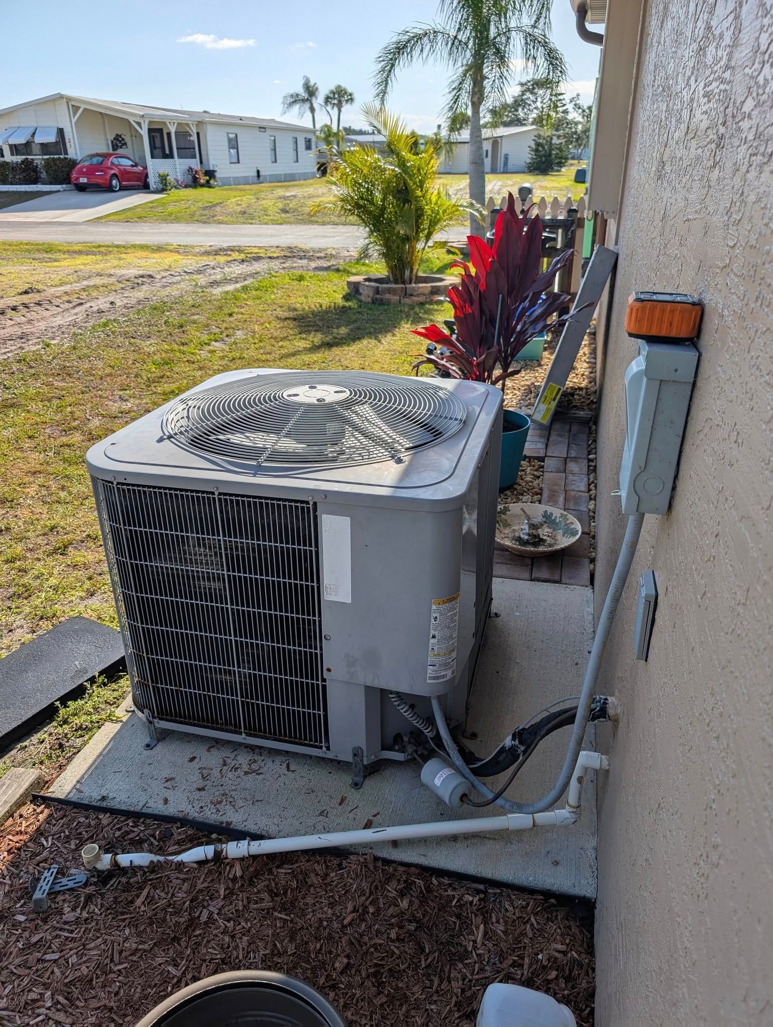 An air conditioner is sitting on the side of a house.