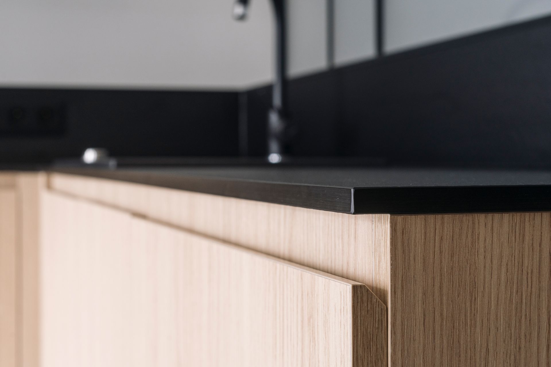 Basement bar with granite countertop, wooden cabinets, and a wine fridge. TV mounted above bar.