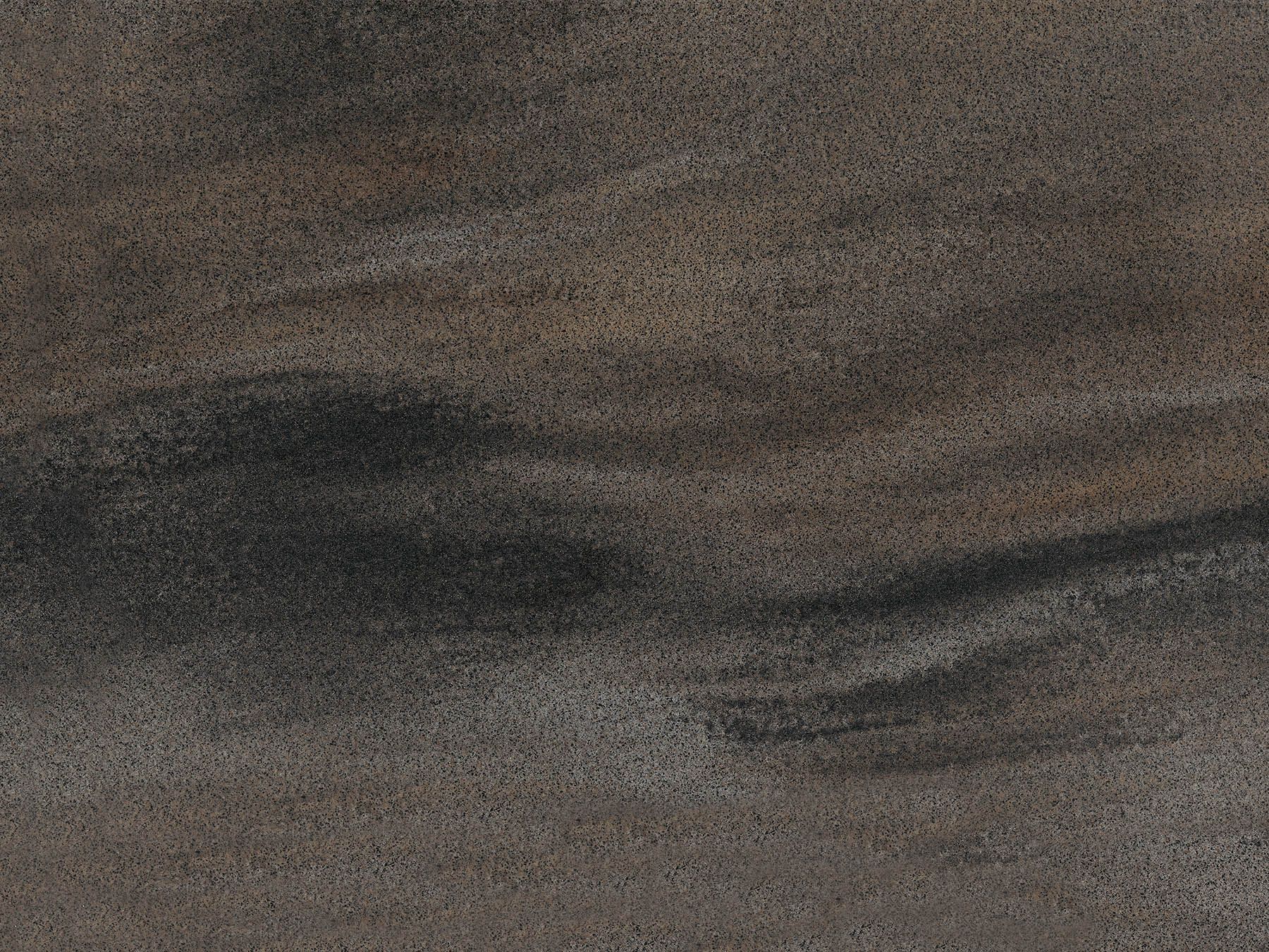 Dark gray and brown speckled stone surface with swirling darker patterns.