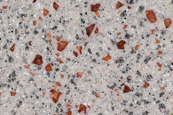 White speckled surface with scattered dark gray and reddish-brown aggregates.