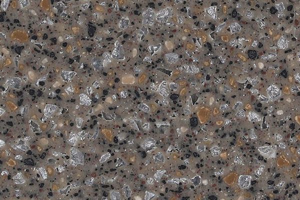 Close-up of a speckled, textured surface with gray, black, tan, and clear crystals.