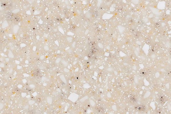 Close-up of a speckled beige and white countertop surface with small black and yellow flecks.