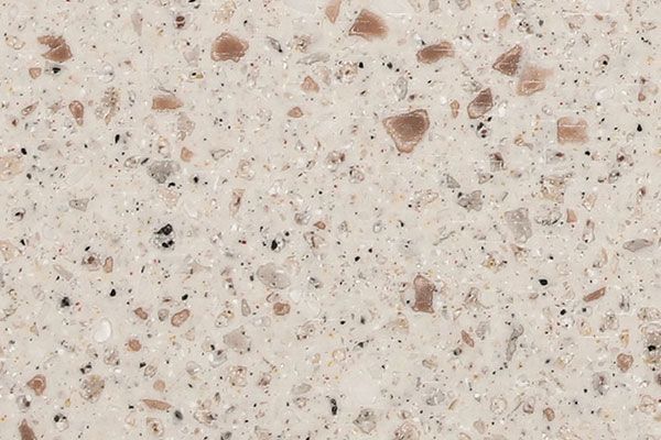 Close-up of beige quartz countertop with brown and black flecks.