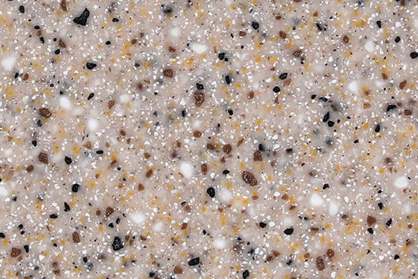 Close-up of speckled beige surface with brown, black, yellow and white flecks.